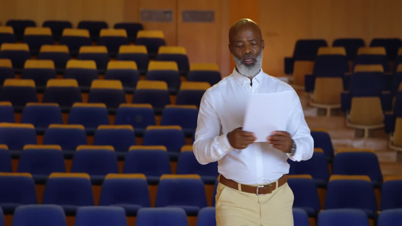 hombre de negocios afroamericano practicando el discurso en un auditorio vacío 4k