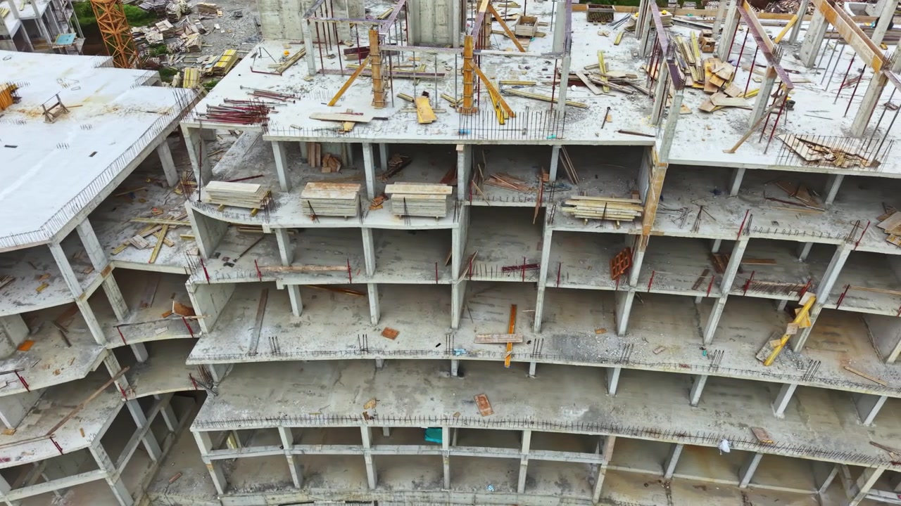 Aerial building overview. Drone footage showcasing urban construction details. Flying camera captures detailed scene of city building development and supporting structures