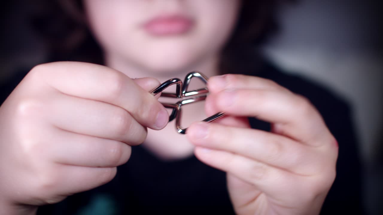 4k de primer plano de la cara del niño resolviendo acero 3d rompecabezas o acertijos