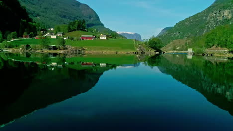 Drone-Shot-of-Amazing-Coastline-of-Norway,-Flam-Village,-Fjord-and-Green-Hills-Reflections-on-Water-on-Sunny-Day