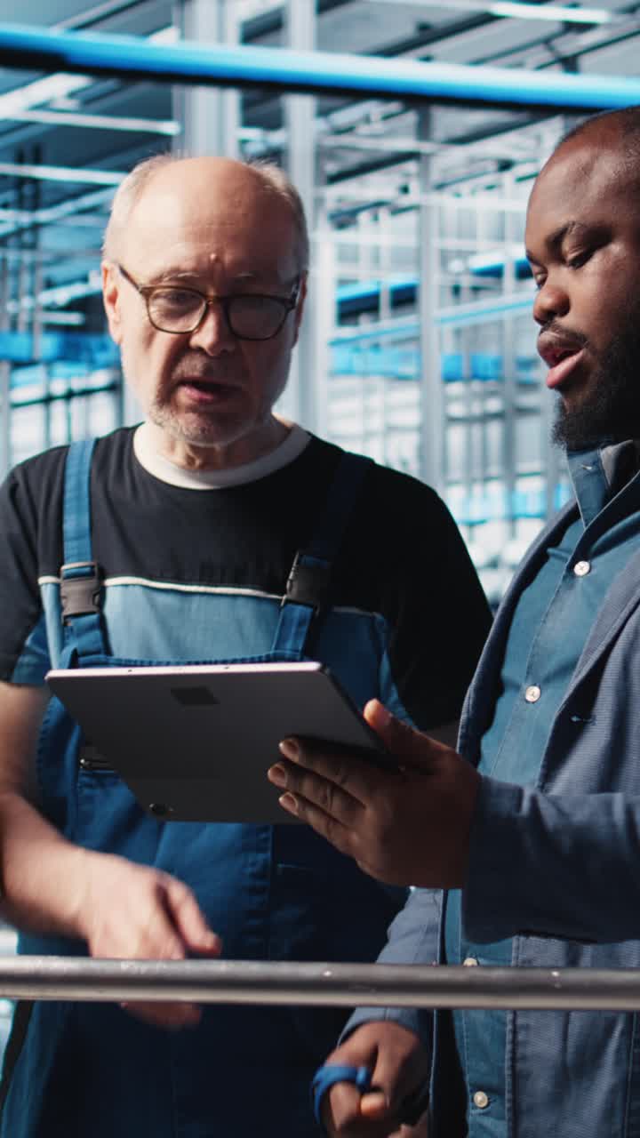 Vertical video Manager overseeing smart factory, giving instructions to engineers