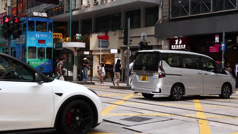 hong kong city street scene with tram and cars