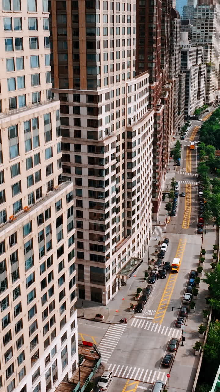 Freeway with heavy traffic at the waterfront of New York. Drone flight along the multistoried buildings facing the East River. Vertical video