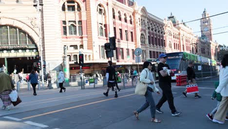 people crossing street near victorian train station