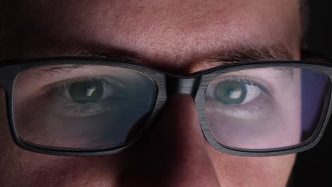 close up of a mans eyes reading off computer screen through glasses