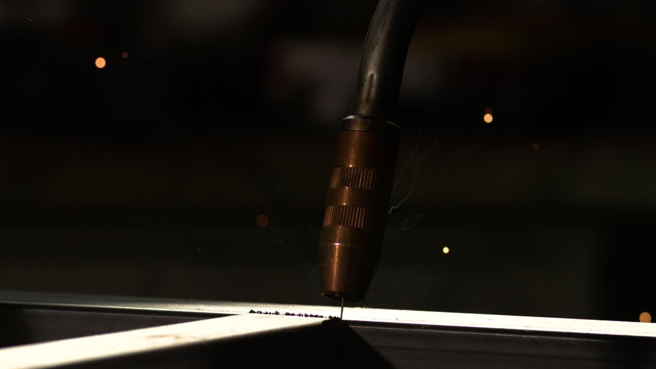 용접자는 모양의 금속 파이프에서 일하고 산업 배경으로 슈퍼 느린 움직임 800fps에서 용접을 시작합니다.