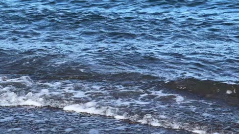 Primer-Plano-De-Suaves-Olas-Del-Océano-Con-Espuma-Ligera,-Atmósfera-Serena-Junto-Al-Mar