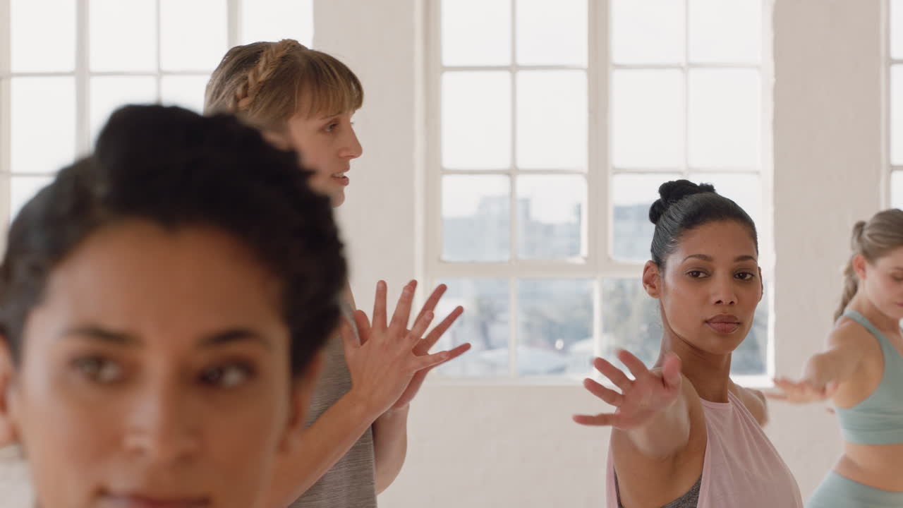 instructor de clase de yoga enseñando pose de guerrero a un hermoso grupo de mujeres disfrutando de un estilo de vida saludable haciendo ejercicio en la meditación del gimnasio