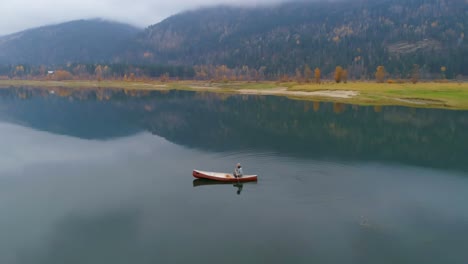 Man-rowing-boat-with-his-dog-on-a-lake-4k