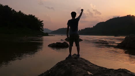 man celebrating sunset by the river