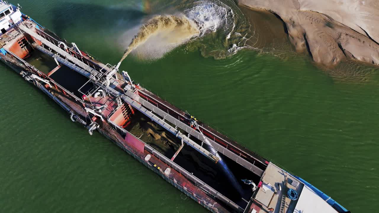 Aerial shot of a dredger unloading dredged sand on a big river, sunny day