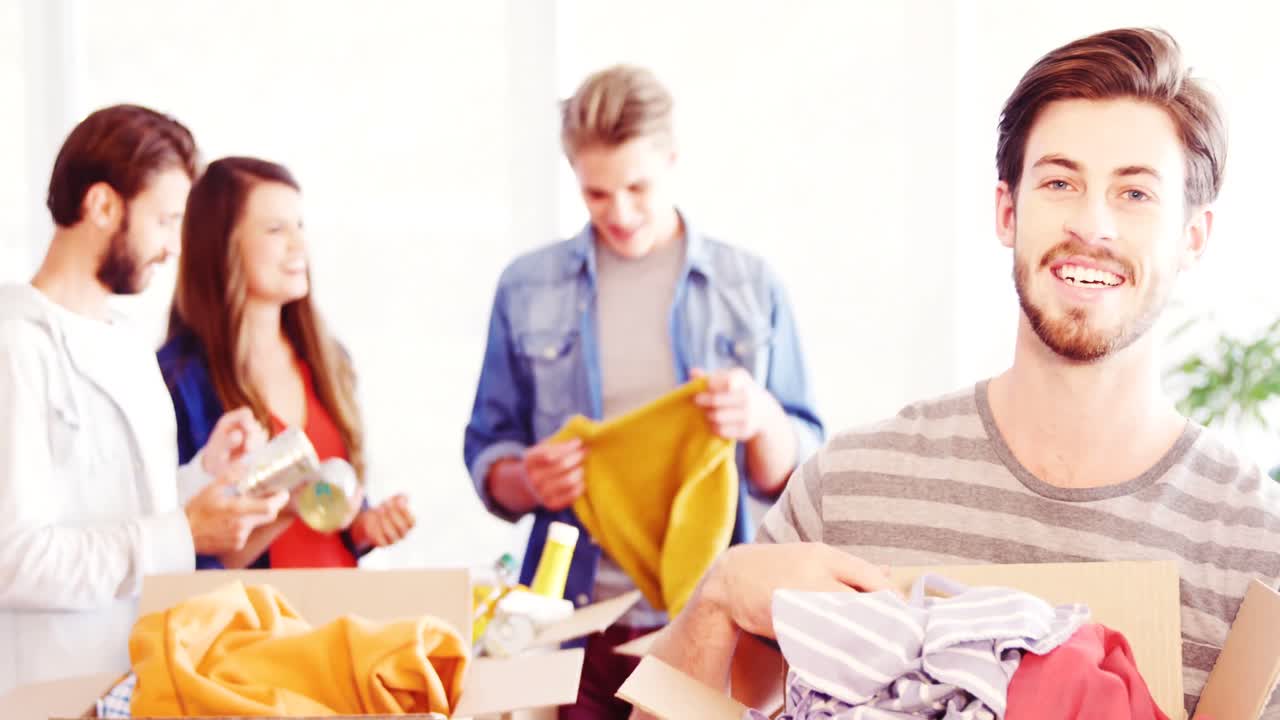 기부 상자 에 옷 을 들고 있는 행복 한 임원