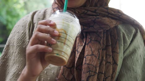 woman drinking iced coffee