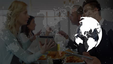 four professionals sharing pastries and coffee using digital tablets under floating business globe
