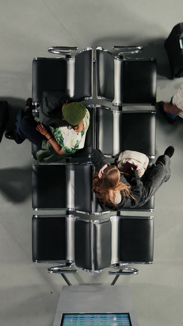Ripresa dall'alto di giovani donne in attesa nella lounge dell'aeroporto.