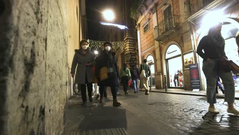 street at night in rome, italy with people walking