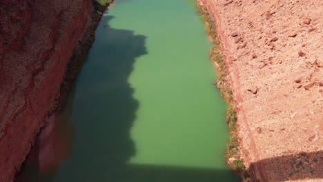 tilting up shot above the colorado river to reveal navajo bridge at the mouth of the grand canyon