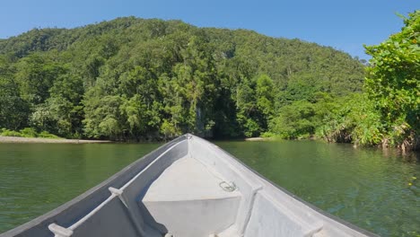 Bow-of-boat-sailing-toward-jungle-on-Kali-Biru-blue-river-of-Raja-Ampat-archipelago-in-Indonesia