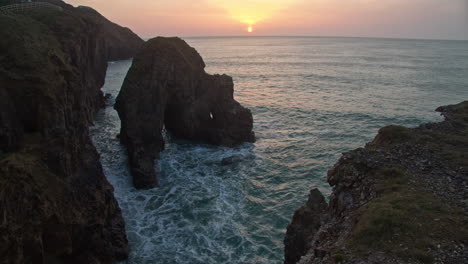 sunset scenery and rock formation at perranporth beach in england - static shot