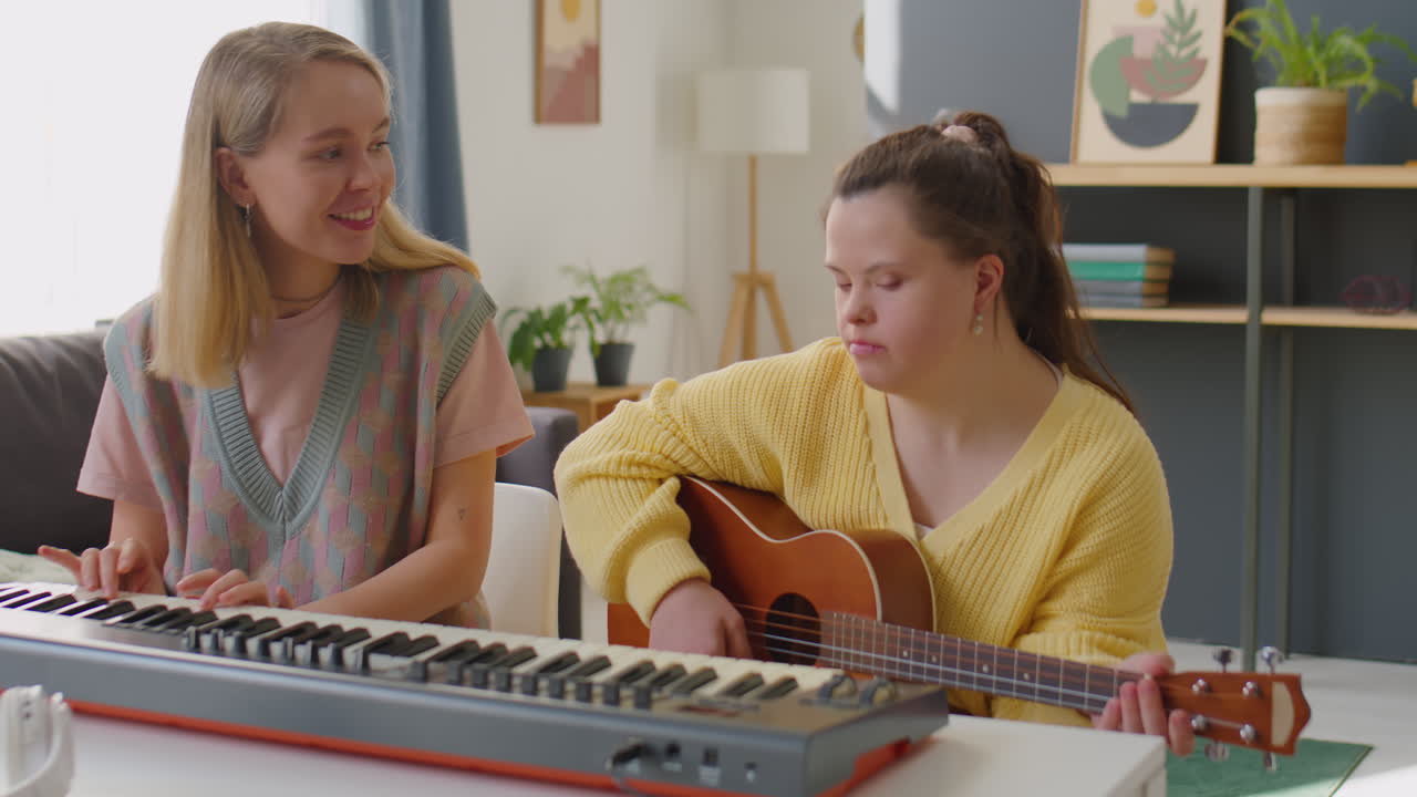 Girl with Down Syndrome Playing Guitar at Music Lesson with Teacher