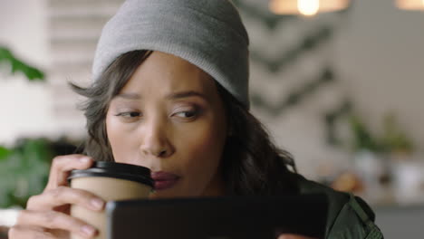 close-up-young-african-american-woman-using-tablet-computer-in-cafe-watching-online-entertainment-reading-social-media-messages-enjoying-drinking-coffee-relaxing-in-trendy-restuarant