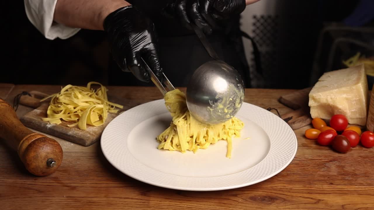 Chef professionista che serve tagliatelle fresche su un piatto