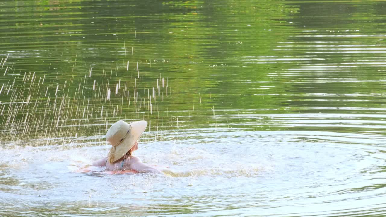 수영복과  모자를 입은 여자가 호수, 강, 연못에서 부풀어올릴 수 있는 원과 함께 떠다니고 있습니다. 소녀는 파란 물을 가진 수영장에서 수영 반지에 휴식을 취합니다. 여행, 휴가, 주말, 휴일, 자연에서 휴식을 취하고, 휴식, 휴식