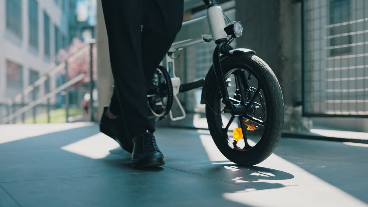 A person walking alongside an e-bike in an urban setting