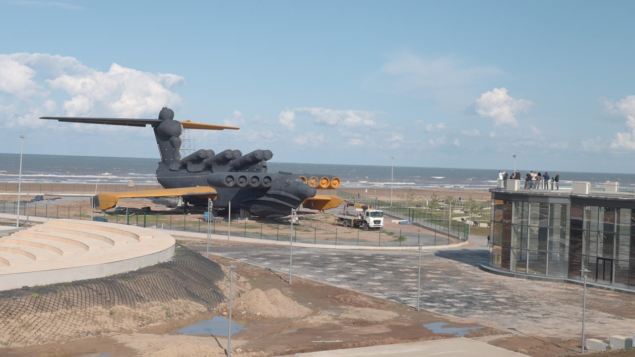 Coastal Sculpture Giant Airplane Overlooking Beach, Engineer Inspecting Installation From Observation Deck. Creative