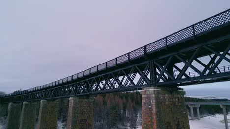 mirando por encima del viaducto de findhorn hacia el bosque y el paisaje invernal con río helado