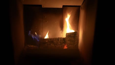 closeup view of firewood burning inside home firebox with dancing flames in slow motion.