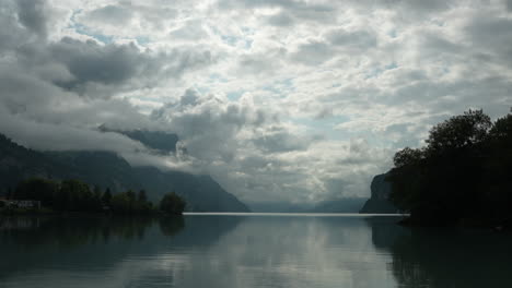timelapse of dramatic clouds moving above walensee lake with alpine peaks and reflections in switzerland