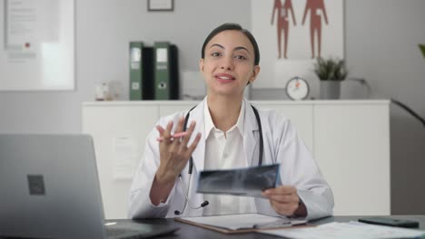 happy indian female doctor explaining x ray report to patient