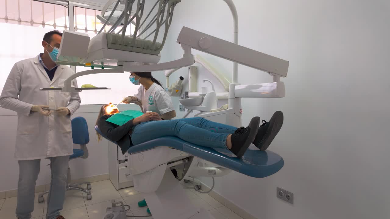 mujer quitando un diente en el dentista