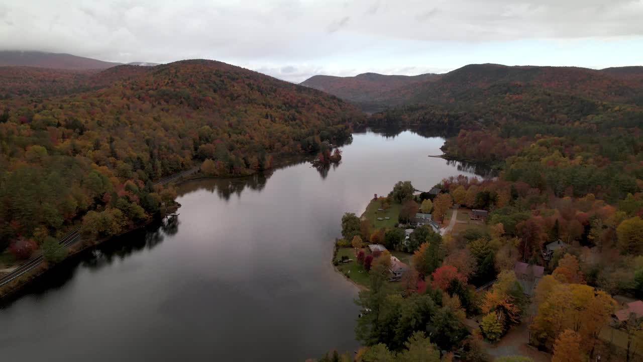 inclinación aérea hacia abajo colores de otoño sobre el lago en otoño en vermont