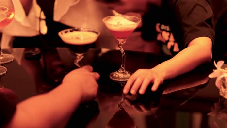 hands reaching for drinks on a table