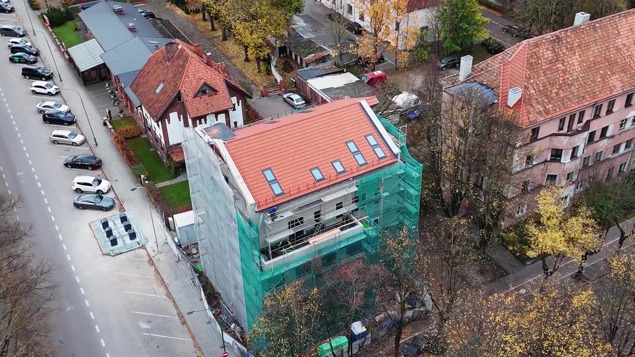 Bygningsrenovering pågår på en fleretagers struktur i et trebevokst nabolag, luftfoto