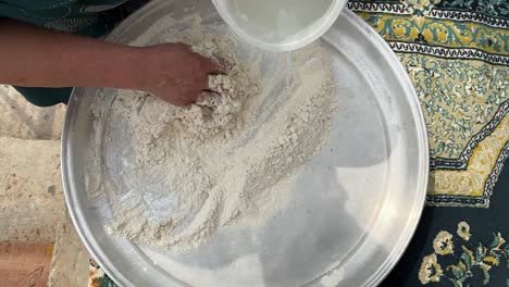 add water to flour to make traditional sour dough bread fermentation process with warm liquid and cook bake a flat smoky bread in a tube wood fire charcoal persian turkish germany bread in japan skill