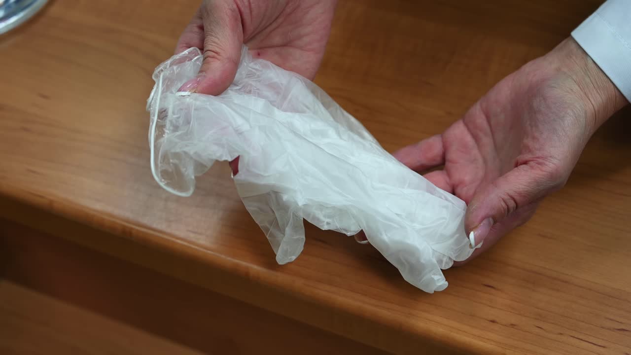 Hands of a woman pharmacist giving latex medicinal gloves to a man. Corona Virus idea. Overhead