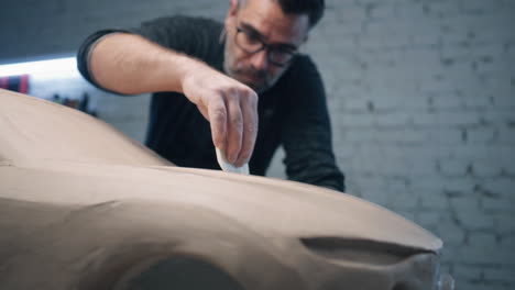 car designer working on clay model