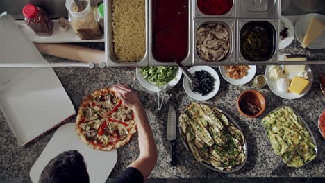 cook preparing pizza for delivery on kitchen