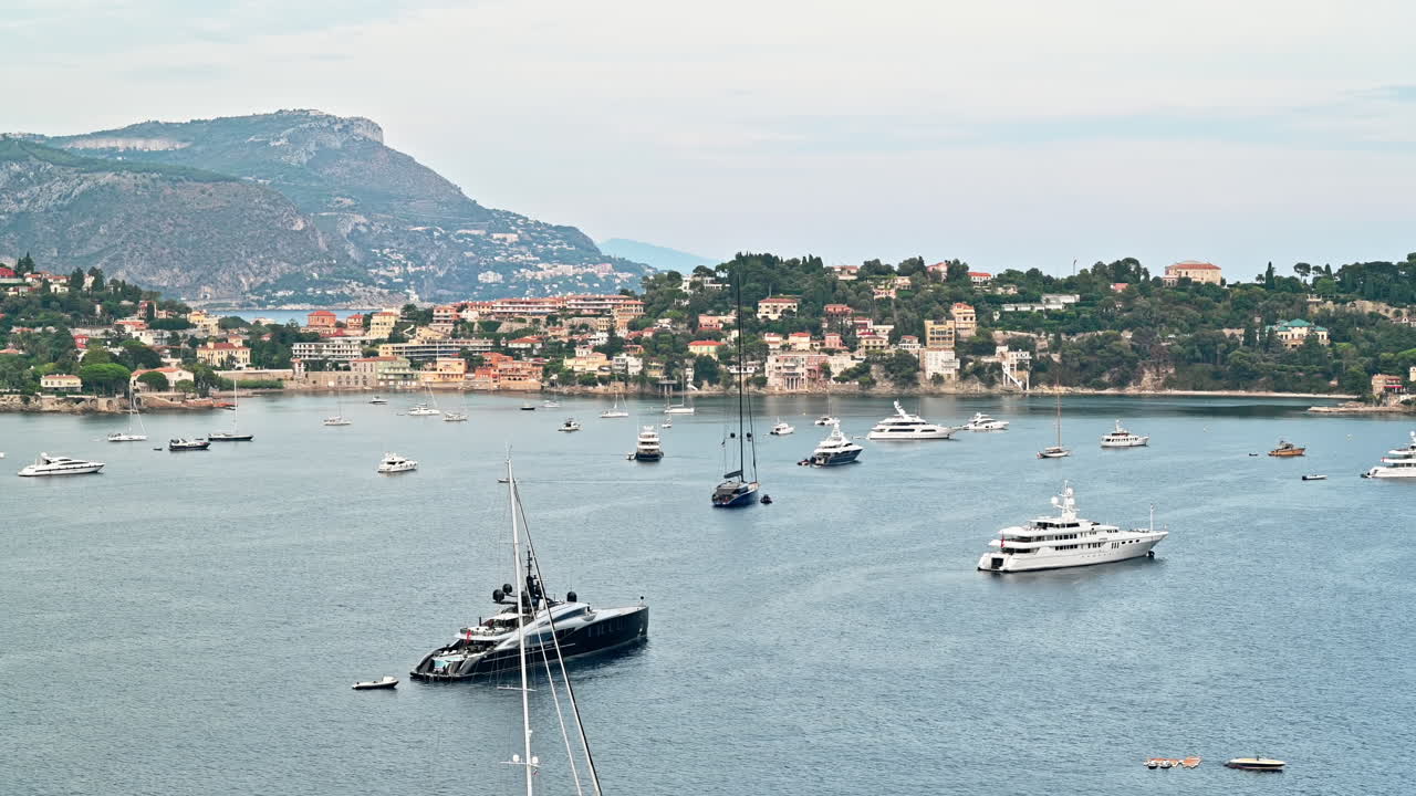 Vista della costa del Mar Mediterraneo a Saint-Jean-Cap-Ferrat, colline con vegetazione, edifici residenziali, yacht, Francia