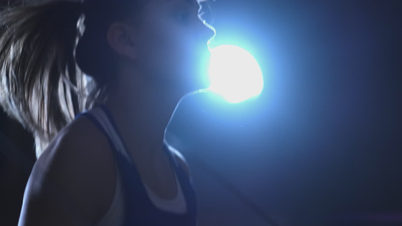 Close-up of a boxer girl's face jumping on a rope during an active workout