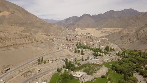 Winding-Road-On-The-Moonland-With-Lush-Green-PoplarTrees-On-The-Foreground-Near-The-Lamayuru-Monastery-And-Village-In-Leh,-Ladakh,-India