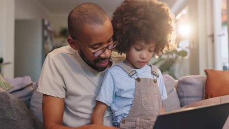 father and son using a laptop at home