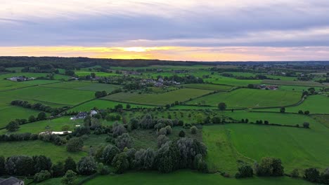 yellow and orange sun beams under cloudy skies illuminating landscape