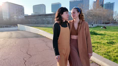 a lesbian couple kissing in an urban park setting