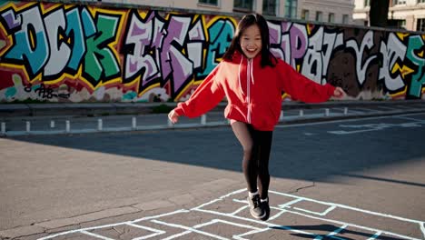 happy girl playing hopscotch