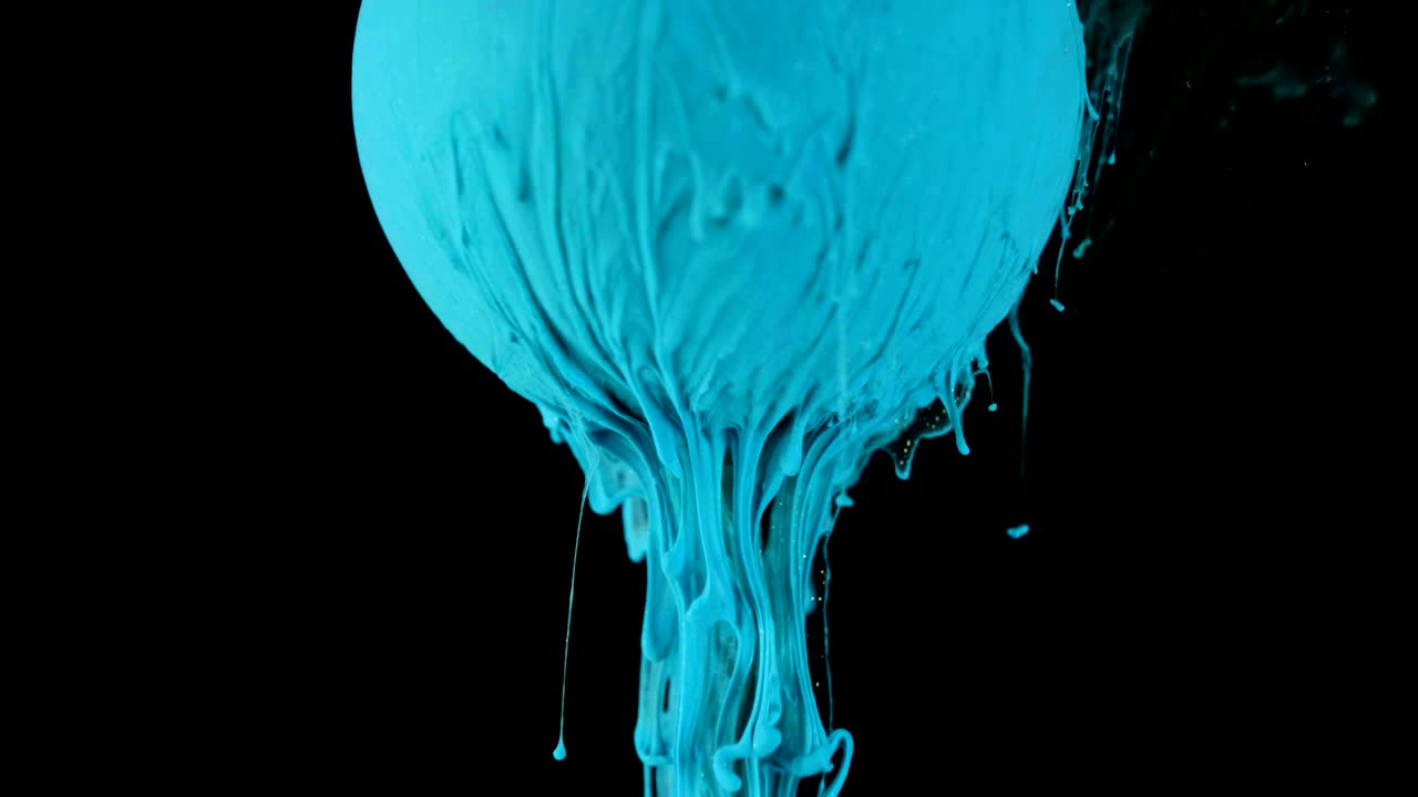 Multicolored ink paint slowly flows from the ball