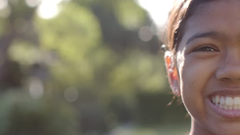 smiling girl outdoors enjoying sunny day, close-up of face with blurred background, copy space